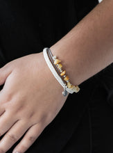 Load image into Gallery viewer, Infused with a braided white leather band, gray cording knots around pieces of yellow rocks and glistening silver accents for a seasonal look. Features an adjustable sliding knot closure.  Sold as one individual bracelet.   