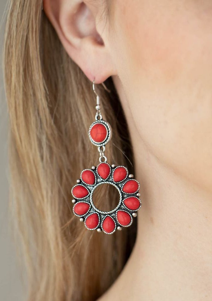 A fiery collection of red teardrop stones fan out from a textured silver ring, creating a scalloped floral frame at the bottom of a round red stone dotted frame. Earring attaches to a standard fishhook fitting.  Sold as one pair of earrings.  Always nickel and lead free.  Fashion Fix Exclusive June 2021