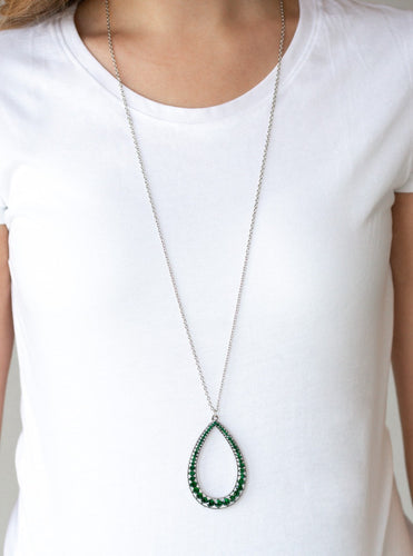 An oversized silver teardrop frame is encrusted in glittery green rhinestones that gradually increase in size at the bottom for a showstopping finish. The sparkling pendant swings from the bottom of a lengthened silver chain for a slimming finish. Features an adjustable clasp closure.  Sold as one individual necklace. Includes one pair of matching earrings.  