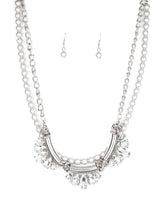Load image into Gallery viewer, A classic strand of silver pearls and dramatic silvery chain drape below the collar. Infused with heavy metal accents, teardrop and marquise cut white rhinestone frames connect into a show-stopping fringe. Features an adjustable clasp closure.  Sold as one individual necklace. Includes one pair of matching earrings.