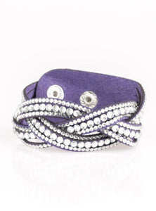 Varying in size, glassy white rhinestones are encrusted along interwoven blue suede bands, creating blinding shimmer across the wrist. Features an adjustable snap closure. Sold as one individual bracelet.