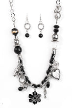 Load image into Gallery viewer, Black and ivory cording is braided through a chunky silver chain. A unique variety of charms decorate the piece including a delicate flower and a heart. Heart is inscribed with the phrase "With All My Heart" on one side and a short bible verse on the other that reads, "Love the Lord thy God with all your heart. Luke 10:27." Features an adjustable clasp closure.   Sold as one individual necklace. Includes one pair of matching earrings.