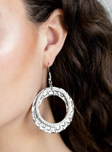 Load image into Gallery viewer, Encrusted in glassy white rhinestones, a glittery silver hoop links with a thick silver hoop embossed in metallic pebble-like patterns, creating a refined lure. Earring attaches to a standard fishhook fitting.  Sold as one pair of earrings.