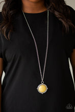Load image into Gallery viewer, A smooth yellow stone is pressed into a shimmery silver frame radiating with metallic rope-like texture, creating a bold pendant at the bottom of a lengthened silver chain. Features an adjustable clasp closure.  Sold as one individual necklace. Includes one pair of matching earrings.  Always nickel and lead free.