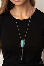 Load image into Gallery viewer, An oval turquoise stone is pressed into a glistening silver frame stamped in antiqued tribal inspired patterns. A shimmery silver chain tassel swings from the bottom of the earthy pendant for a whimsical finish. Features an adjustable clasp closure.  Sold as one individual necklace. Includes one pair of matching earrings.