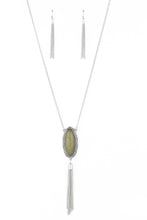 Load image into Gallery viewer, An oval Military Olive stone is pressed into a glistening silver frame stamped in antiqued tribal inspired patterns. A shimmery silver chain tassel swings from the bottom of the earthy pendant for a whimsical finish. Features an adjustable clasp closure.  Sold as one individual necklace. Includes one pair of matching earrings.
