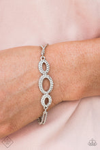 Load image into Gallery viewer, Encrusted in glassy white rhinestones, shiny silver ovals delicately connect across the front of the wrist for a timelessly sophisticated look. Features an adjustable clasp closure.