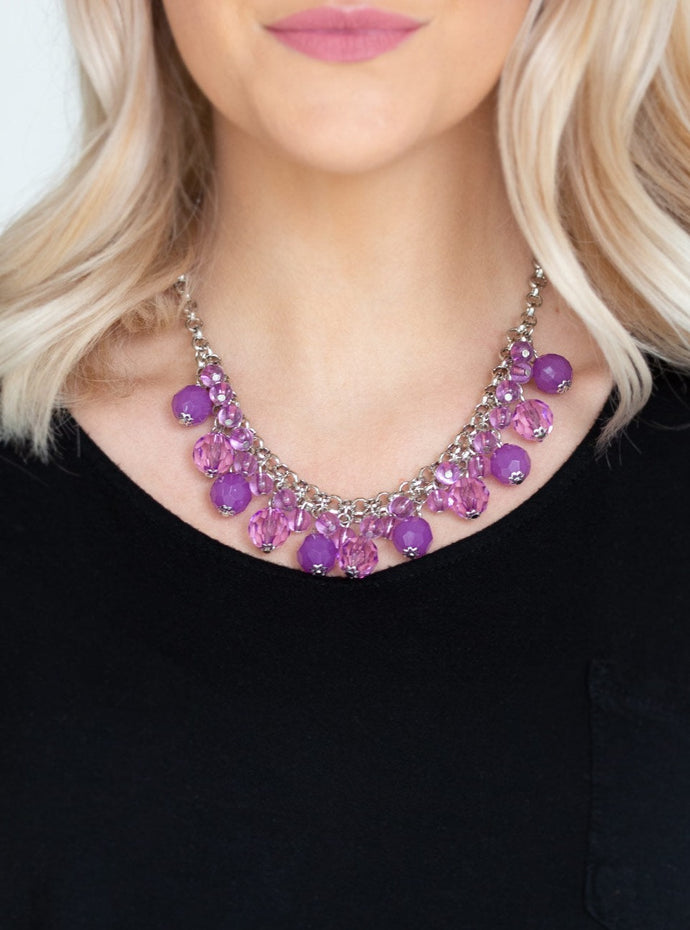   A collection of glassy and opaque purple crystal-like beads swing from the bottom of interlocking silver chains, creating a fabulous fringe below the collar. Features an adjustable clasp closure.  Sold as one individual necklace. Includes one pair of matching earrings. 