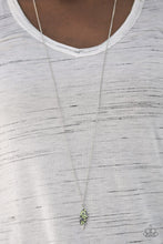 Load image into Gallery viewer, Attached to an elegantly elongated chain, a silver leaf pendant swings from the bottom of the slimming palette. Embossed in lifelike textures, the leafy pendant is encrusted in dazzling green rhinestones for a timeless finish. Features an adjustable clasp closure.  Sold as one individual necklace. Include one pair of matching earrings.