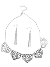 Load image into Gallery viewer, Shimmery metallic plates swing from a classic silver chain, creating a geometric fringe. Decorated in a Southwestern textile pattern, the stenciled plates fall just below the collar in an airy fashion. Features an adjustable clasp closure.  Sold as one individual necklace. Includes one pair of matching earrings.