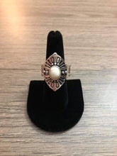 Load image into Gallery viewer, A black stone bead is pressed into the center of an angular silver frame radiating with studded and antiqued textures. Features a stretchy band for a flexible fit.  Sold as one individual ring.  Always nickel and lead free.