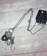 Load image into Gallery viewer, A silver bird charm, silver heart charms, and collection of white pearls and opaque green  crystal-like beads swing from the bottom of a lengthened silver chain for a whimsically clustered look. Features an adjustable clasp closure.  Sold as one individual necklace. Includes one pair of matching earrings.  Exclusive!