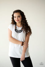 Load image into Gallery viewer, Separated by shimmery silver fittings, black, brown, and silver seed beaded geometric frames give way to layers of black seed beads down the chest for a tribal inspired flair. Features an adjustable clasp closure.  Separated by shimmery silver fittings, a collection of black and brown seed beads are threaded along stretchy bands, creating a colorful geometric pattern around the wrist.
