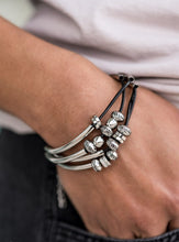 Load image into Gallery viewer, Multiple strands of black cord are fitted with long, curved cylinders that meet in the middle. The sliding bars are separated by small antiqued silver loops that mimic pipe fittings, making this a perfect addition to any industrial look. Features an adjustable clasp closure.