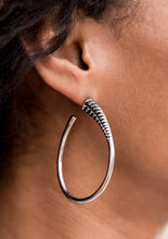 Load image into Gallery viewer, A spiral of texture resembling a coil anchors an exaggerated oblong silver hoop that wraps around the ear. The high-sheen finish on the curved bar adds a hint of drama, as it refracts the light in a knockout finish. Earring attaches to a standard post fitting. Hoop measures approximately 1 1/2" in diameter.