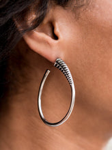 Load image into Gallery viewer,  A spiral of texture resembling a coil anchors an exaggerated oblong silver hoop that wraps around the ear. The high-sheen finish on the curved bar adds a hint of drama, as it refracts the light in a knockout finish. Earring attaches to a standard post fitting. Hoop measures approximately 1 1/2" in diameter.