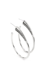 Load image into Gallery viewer, A spiral of texture resembling a coil anchors an exaggerated oblong silver hoop that wraps around the ear. The high-sheen finish on the curved bar adds a hint of drama, as it refracts the light in a knockout finish. Earring attaches to a standard post fitting. Hoop measures approximately 1 1/2" in diameter.