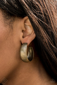 Etched in gritty linear patterns, thick brass hoops boldly curl around the ear for a statement-making finish. Earring attaches to a standard post fitting. Hoop measures approximately 1 1/4” in diameter.