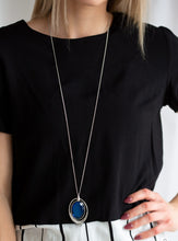Load image into Gallery viewer, An oversized blue gem swings from the top of an airy silver frame, creating a refined double pendant at the bottom of a lengthened silver chain. As if dipped in glitter, the bottom of the silver frame is encrusted in glassy white rhinestones for a glamorous finish. Features an adjustable clasp closure.  Sold as one individual necklace. Includes one pair of matching earrings.