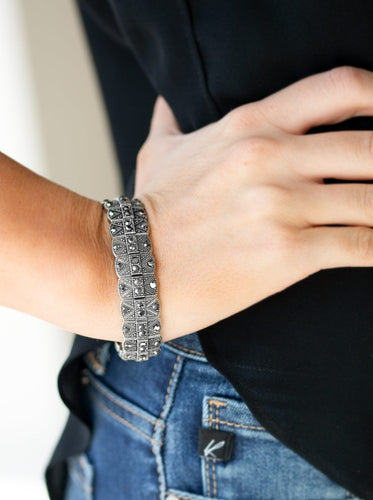 Encrusted in glittery hematite rhinestones, ornately studded silver frames are threaded along stretchy bands for an edgy-glamorous look.  Sold as one individual bracelet.  