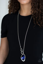 Load image into Gallery viewer, A faceted blue gem is nestled inside of a shimmery silver frame encrusted in dainty white rhinestones. The glittery pendant asymmetrically links with abstract silver frames at the bottom of a lengthened silver rounded snake chain for a modern look. Features an adjustable clasp closure.  Sold as one individual necklace. Includes one pair of matching earrings.