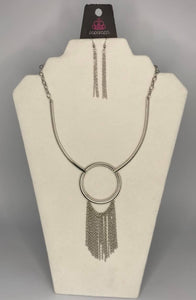 Attached to two bowing shiny silver bars, a shiny silver hoop gives way to a matching chain fringe, creating a statement-making look below the collar. Features an adjustable clasp closure.  Sold as one individual necklace. Includes one pair of matching earrings.  Always nickel and lead free.  Fashion Fix February 2021 Exclusive