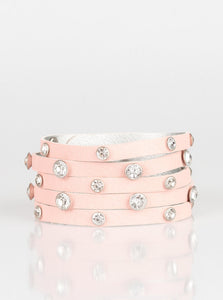 Dotted with glassy white rhinestones, a thick pink leather band has been spliced into five glittery strands around the wrist for a sassy look. Features an adjustable snap closure.  Sold as one individual bracelet.