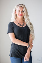 Load image into Gallery viewer, NECKLACE AND EARRINGS:  Gradually increasing in size near the center, radiant gunmetal bars spin into charming rosebud frames below the collar for a whimsical look. Features an adjustable clasp closure.  BRACELET:  Brushed in a high-sheen shimmer, radiant gunmetal bars spin into charming rosebud frames. The glistening rosebuds are threaded along a stretchy band, wrapping around the wrist for a whimsical look.