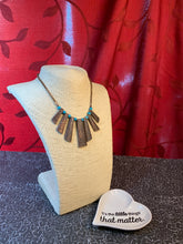Load image into Gallery viewer, Etched in shimmery textures, glistening copper plates trickle along the bottom of a copper chain, creating a tribal inspired fringe below the collar. Refreshing turquoise stone beads trickle between the antiqued plates, adding an artisanal flair to seasonal palette. Features an adjustable clasp closure.  Sold as one individual necklace. Includes one pair of matching earrings.