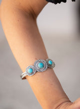 Load image into Gallery viewer, Three round turquoise stones dot the centers of three hammered silver frames, creating a rustic centerpiece atop an antiqued silver cuff.