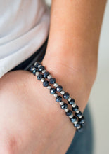Load image into Gallery viewer, Brushed in a metallic sheen, glittery blue crystal-like beads and faceted silver beads are threaded along stretchy elastic bands. Matching beads swing from the wrist, creating clustered centerpieces.
