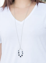Load image into Gallery viewer, Varying in size, an array of glittery white and blue rhinestones are encrusted along a shimmery silver hoop. The sparkling pendant swings from the bottom of an elongated silver chain for a glamorous finish. Features an adjustable clasp closure.  Sold as one individual necklace. Includes one pair of matching earrings.