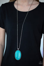 Load image into Gallery viewer, Chiseled into a tranquil oval, a dramatically over sized turquoise stone pendant swings from the bottom of a lengthened silver chain. Glassy white rhinestones dust the pendant's fitting for a refined flair. Features an adjustable clasp closure.  Sold as one individual necklace. Includes one pair of matching earrings.