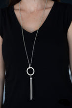 Load image into Gallery viewer, Encrusted in dazzling white rhinestones, a shimmery silver hoop swings from the bottom of an elegantly elongated silver chain for a refined look. A glistening silver tassel swings from the bottom of the glittery pendant for a flirty flair. Features an adjustable clasp closure.  Sold as one individual necklace. Includes one pair of matching earrings.  Always nickel and lead free.
