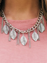 Load image into Gallery viewer, Decorated in lifelike textures, glistening silver leaves swing from the bottom of a bold silver chain. Infused with sections of silver chain tassels, the leafy fringe drapes below the collar for a seasonal look. Features an adjustable clasp closure.  Sold as one individual necklace. Includes one pair of matching earrings.