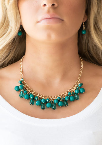 Varying in shape, glassy and polished Quetzal Green beads swing from the bottom of interlocking gold chains. Crystal-like teardrops are sprinkled along the colorful beading, creating a flirtatious fringe below the collar. Features an adjustable clasp closure.  Sold as one individual necklace. Includes one pair of matching earrings.  