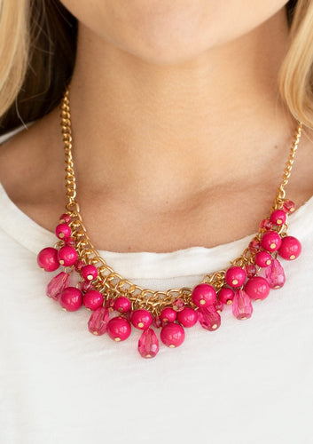 Varying in shape, glassy and polished pink beads swing from the bottom of interlocking gold chains. Crystal-like teardrops are sprinkled along the colorful beading, creating a flirtatious fringe below the collar. Features an adjustable clasp closure.  Sold as one individual necklace. Includes one pair of matching earrings.  