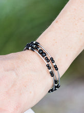 Load image into Gallery viewer, Shiny black beading and shimmery silver accents alternate along a coiled wire to create an earthy infinity wrap style bracelet.  Sold as one individual bracelet.