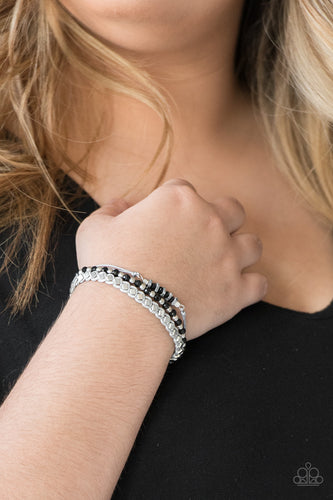 Infused with a strand of faceted black and classic silver beads, shiny gray cording knots around mismatched beads for an edgy look. Features an adjustable sliding knot closure.  Sold as one individual bracelet.  Always nickel and lead free.