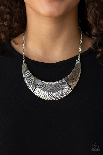 Hammered and embossed in wavy linear textures, antiqued silver plates link into a bold half-moon pendant below the collar for a fierce look. Features an adjustable clasp closure.  Sold as one individual necklace. Includes one pair of matching earrings.  Always nickel and lead free.