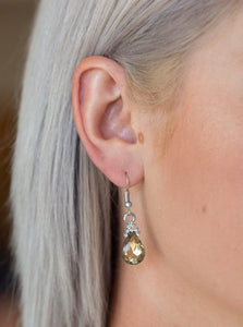 Crowned in glassy white rhinestones, a golden topaz teardrop gem swings from the ear for a glamorous look. Earring attaches to a standard fishhook fitting.  Sold as one pair of earrings.  