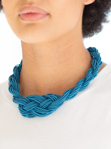 Countless strands of blue seed beads are twisted and knotted together to create an unforgettable statement piece. Features an adjustable clasp closure.  Sold as one individual necklace. Includes one pair of matching earrings.