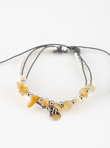 Infused with a braided white leather band, gray cording knots around pieces of yellow rocks and glistening silver accents for a seasonal look. Features an adjustable sliding knot closure.  Sold as one individual bracelet.   