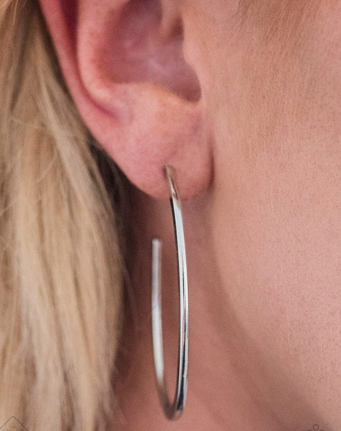Brushed in a high-sheen finish, a flat silver bars curls into an edgy asymmetrical hoop for a casual look. Earring attaches to a standard post fitting. Hoop measures 1 1/4