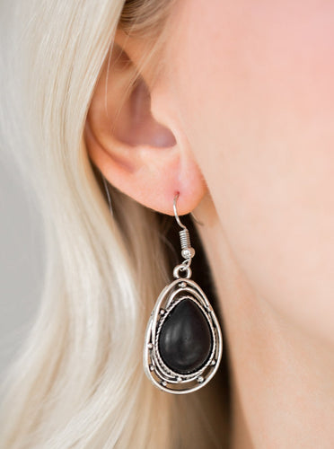 Chiseled into a tranquil teardrop, an earthy black stone is pressed into the center of a twisting silver frame for a handcrafted look. Earring attaches to a standard fishhook fitting.  Sold as one pair of earrings.