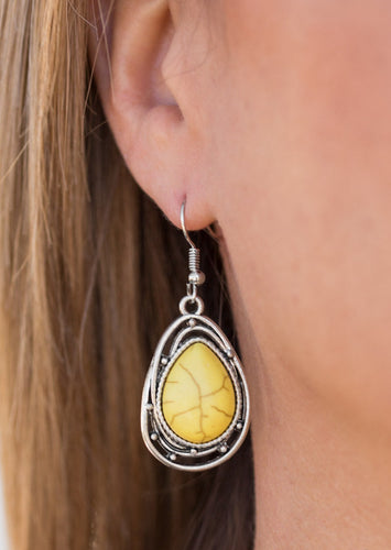 Chiseled into a tranquil teardrop, a sunny yellow stone is pressed into the center of a twisting silver frame for a handcrafted look. Earring attaches to a standard fishhook fitting.  Sold as one pair of earrings.  