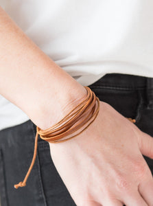 Dainty strands of leather and twine layer across the wrist for an earthy look. Features an adjustable sliding knot closure.  Sold as one individual bracelet.