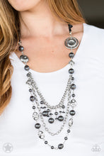 Load image into Gallery viewer, A silky black ribbon replaces a traditional chain to create a timeless look. Pearly dark gray beads and funky silver pieces intermix with varying lengths of silver chains to give a fresh take on a Victorian-inspired piece.  Sold as one individual necklace. Includes one pair of matching earrings.