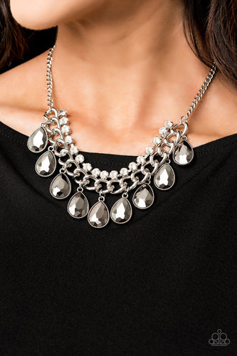 Teardrop hematite rhinestones swing from the bottom of a bold silver chain, creating a dramatic fringe below the collar. A strand of glittery white rhinestones attach to the top of a shimmery silver chain, adding a refined flair to the flashy statement piece. Features an adjustable clasp closure.  Sold as one individual necklace. Includes one pair of matching earrings.  Always nickel and lead free.