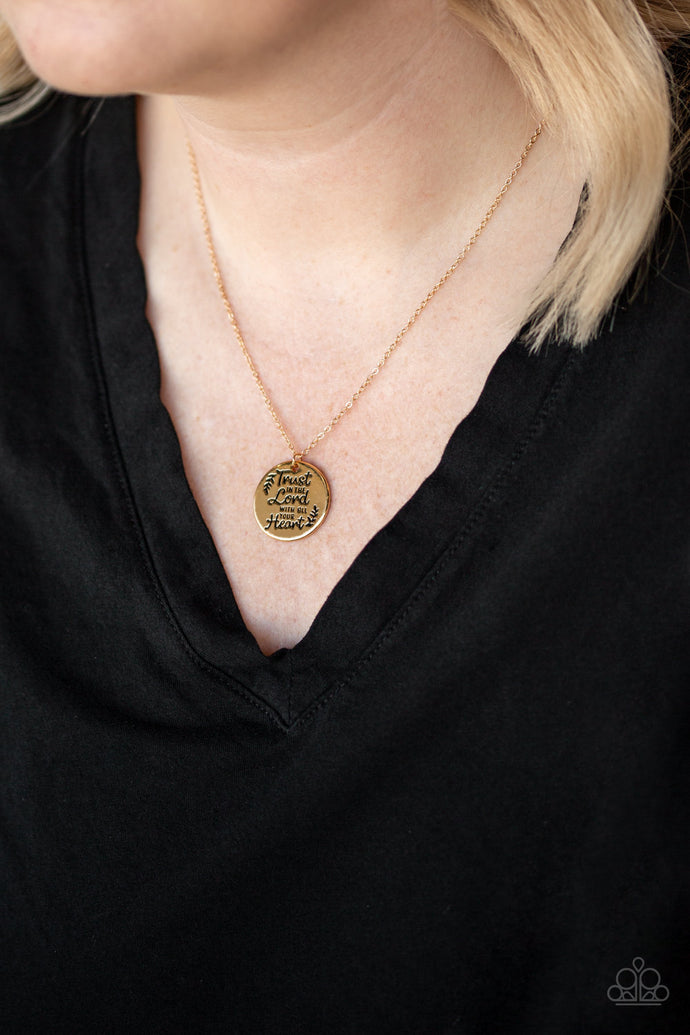 Infused with leafy accents, a dainty gold pendant is stamped in the inspirational phrase, 
